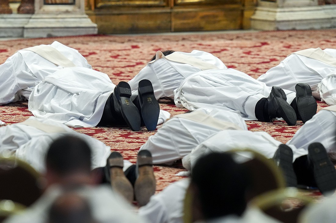 Ordinands lie prostrate during Mass with Pope Leo XIV on the feast of the Sacred Heart of Jesus in St. Peter’s Basilica at the Vatican June 27, 2025. The pope ordained 32 priests from five continents. (CNS photo/Lola Gomez)