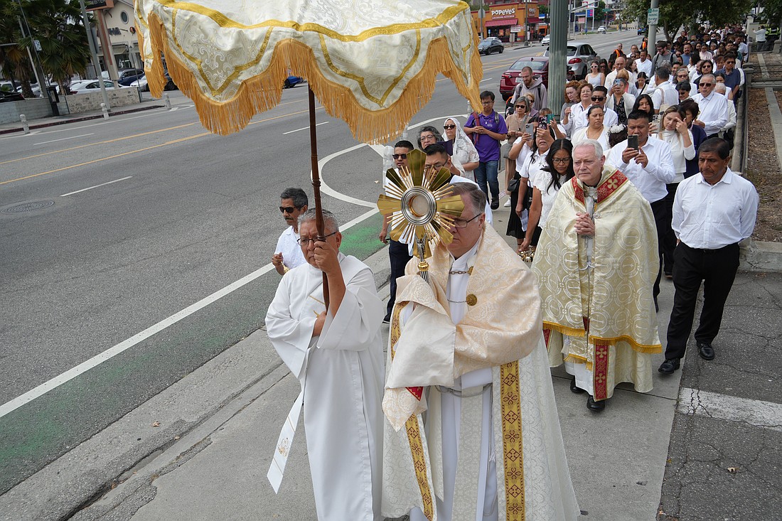 Father Gary Mueller, pastor at St. Vincent DePaul Church in Los Angeles, with Los Angeles Auxiliary Bishop Matthew G. Elshoff close behind, carries the monstrance holding the Blessed Sacrament during Day 2 of the National Eucharistic Pilgrimage's appearance in LA on June 21, 2025. (OSV News photo/Katie Trejo, courtesy Archdiocese of Los Angeles)