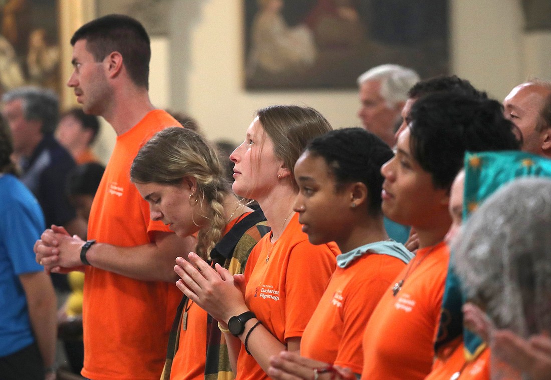 Shayla Elm, a perpetual pilgrim with the Juan Diego Route (center looking up), prays alongside others from her group while attending a Mass to welcome pilgrims at St. John the Evangelist Church in Indianapolis July 16, 2024, just ahead of the National Eucharistic Congress. (OSV News photo/Bob Roller)