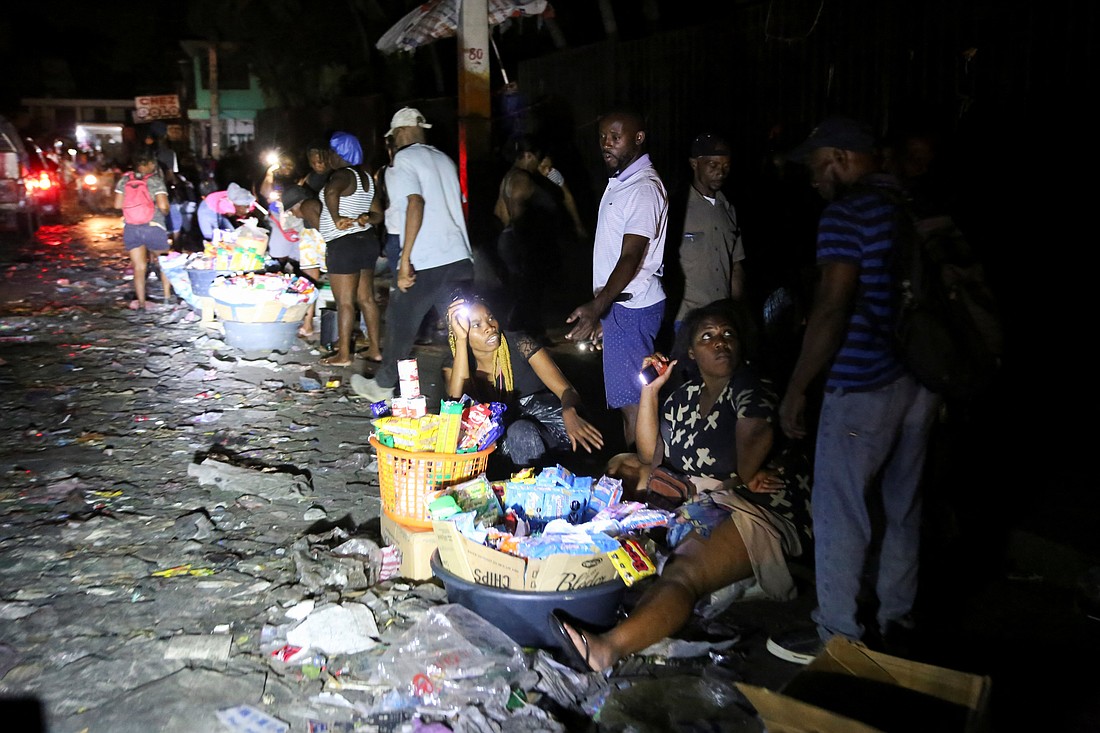 People sell goods on a street during a June 18, 2025, blackout in Port-au-Prince, Haiti's capital, after residents from a nearby town stormed a dam and cut power in protest over government inaction against gang violence in the country. (OSV News photo/Jean Feguens Regala, Reuters)
