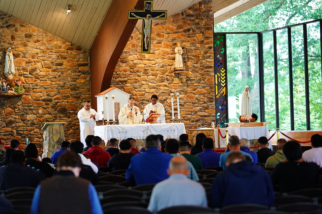 El Padre Javier Díaz, párroco de la Parroquia Cristo Rey, Long Branch (centro), celebra la misa en el Santuario del Ejército Azul. El homilista fue el Padre Neiser Cárdenas, vicario parroquial de la Parroquia San José, Toms River (izquierda). foto de Jose Santiago