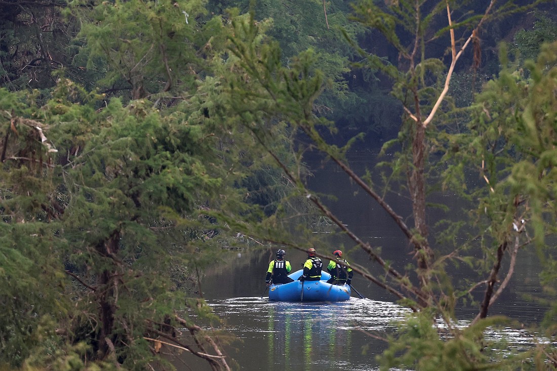 Rescuers paddle an inflatable boat as they search along a waterway in the aftermath of deadly flooding in Kerrville, Texas, July 6, 2025. At least 82 people are dead and at least 41 more are missing after devastating flash floods slammed the Texas Hill Country, with water rescues taking place along the Guadalupe River, which rose rapidly early July 4 to the height of a two-story building. Among the missing were almost a dozen from Camp Mystic in Kerr County, a children's summer camp, officials said July 6. (OSV News photo/Marco Bello, Reuters)