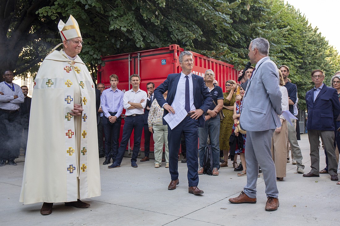 Archbishop Laurent Ulrich of Paris and Philippe Jost, president of Rebâtir Notre Dame de Paris, a public institution responsible for reconstruction efforts of the Parisian cathedral, look on June 23, 2025, as a statue of St. Paul, the first of the 16 now-renovated statues adorning Notre Dame's roof, being lifted by a crane. The crane lift marked the last phase of reconstruction of the cathedral's roof, damaged by the April 2019 fire. (OSV News photo/courtesy David Bordes, Rebâtir Notre-Dame de Paris)