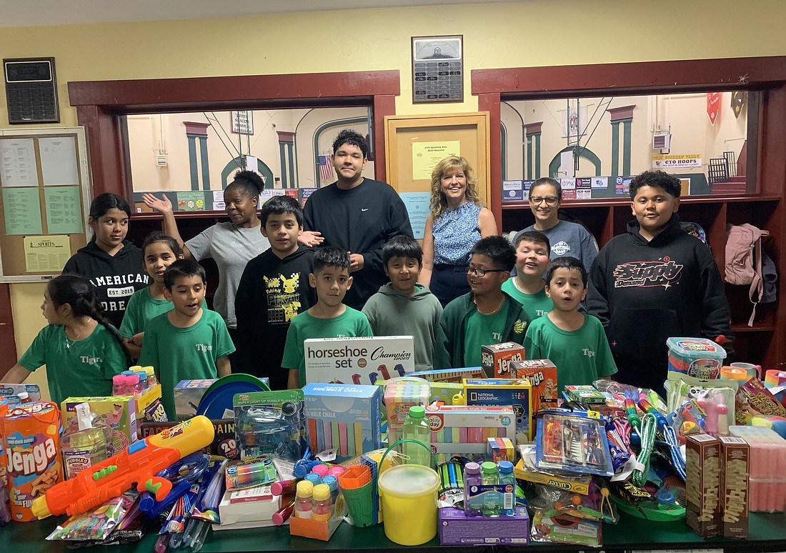 Sharon Skibbee, social concerns chair in St. Alphonsus Parish, Hopewell, stands with children in the Mercer CYO summer camp program with a display of toys collected for CYO through a parish toy drive she organized from May 31-June 8. Courtesy photo
