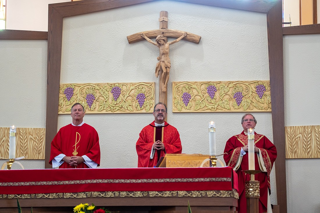 Father Thomas Vala, center, celebrates the anniversary Mass marking the parish’s 60th and his 10th as pastor. At left is Deacon Matt Nicosia and at right is Father Garry Koch, pastor of St. Benedict Parish, Holmdel, who concelebrated. Courtesy photos