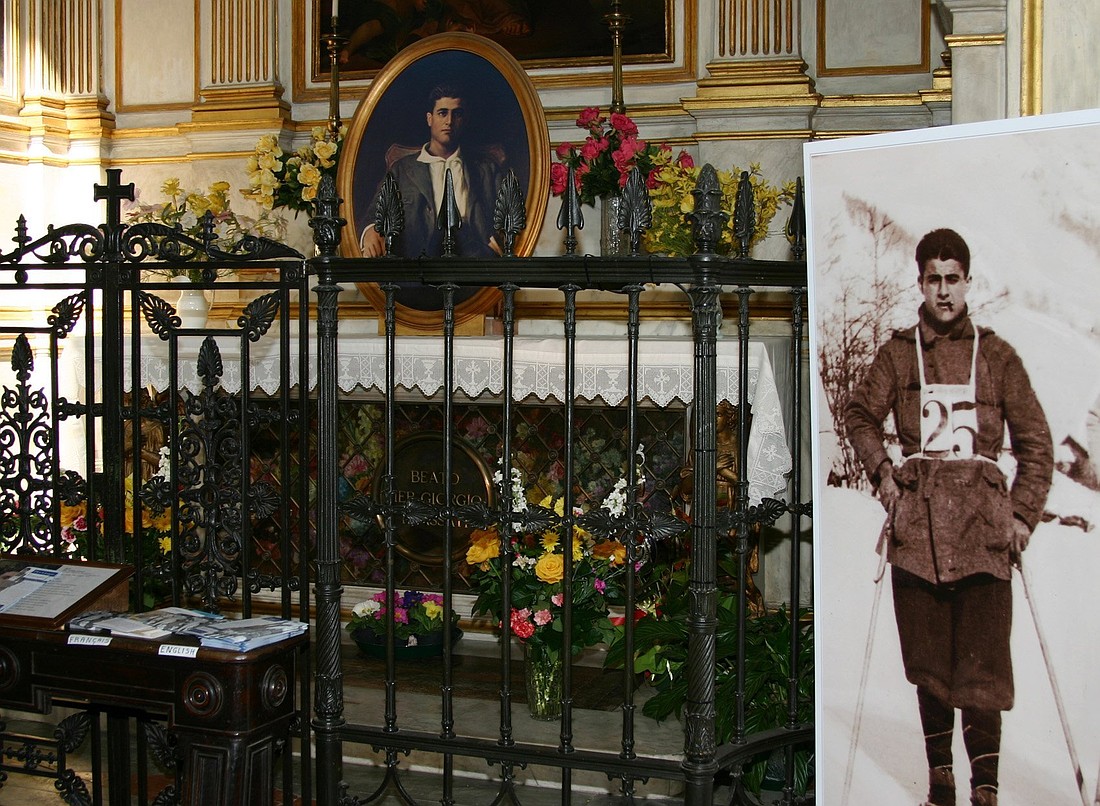 Images of Blessed Pier Giorgio Frassati appear beside and on his tomb at St. John the Baptist Cathedral in Turin, Italy, in this file photo from February 2006. (CNS file photo/Carol Glatz)