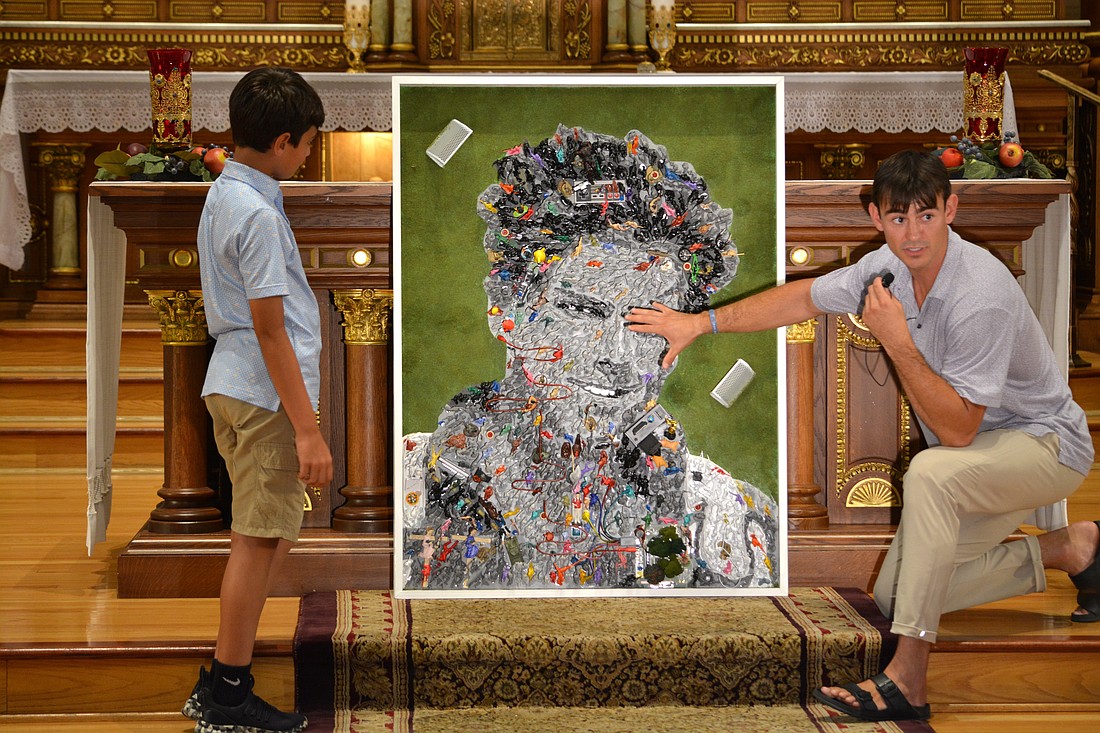 Denver-based multimedia artist Johnny Vrba is pictured inside the St. Hedwig church building of Blessed Carlo Acutis Parish on Chicago's northwest side July 23, 2025. Vrba was answering a boy's questions about a section of a mosaic of Blessed Carlo Acutis he created for the Chicago parish using more than 1,000 toy figurines. (OSV News photo/Simone Orendain)