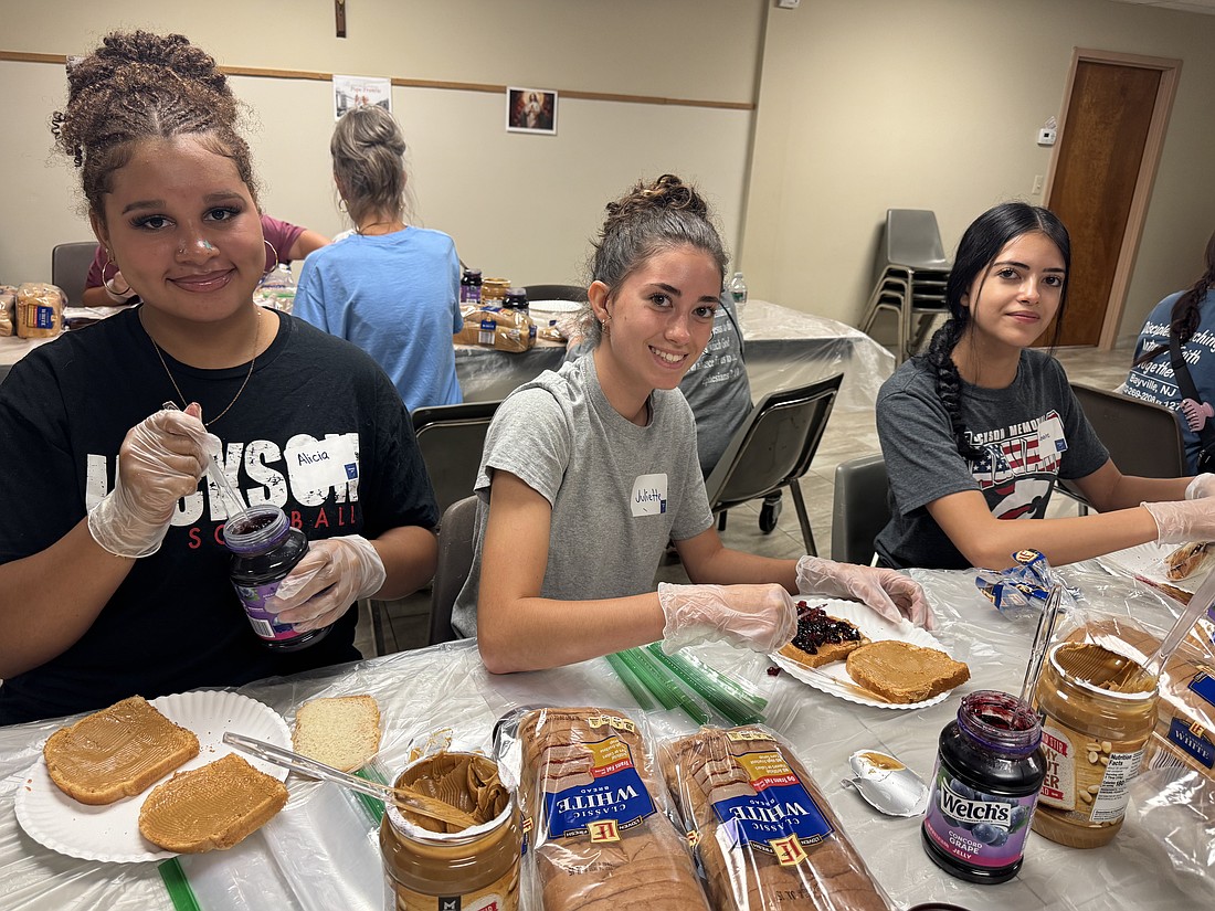 Young people make sandwiches as part of their outreach at Seeds of Service on July 8. Ryan Larason photo