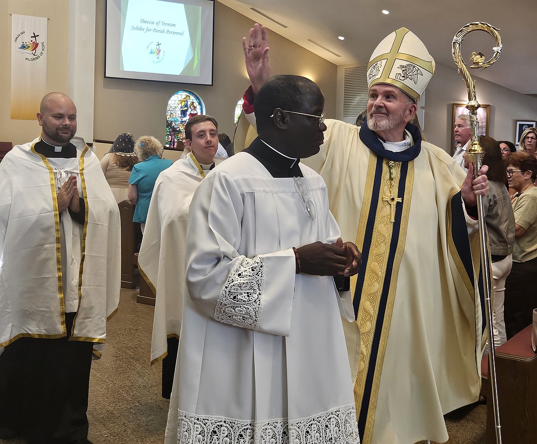 Bishop O'Connell waves to the congregation during the recessional following the Mass he celebrated July 30 in St. Robert Bellarmine Co-Cathedral.