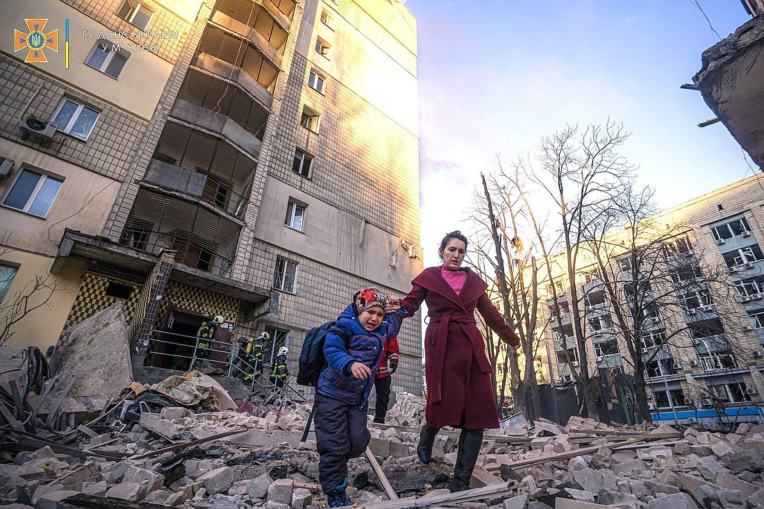A woman with a child evacuates from a residential building damaged by Russian shelling in Kyiv, Ukraine, March 16, 2022. (OSV News photo/State Emergency Service of Ukraine handout via Reuters)