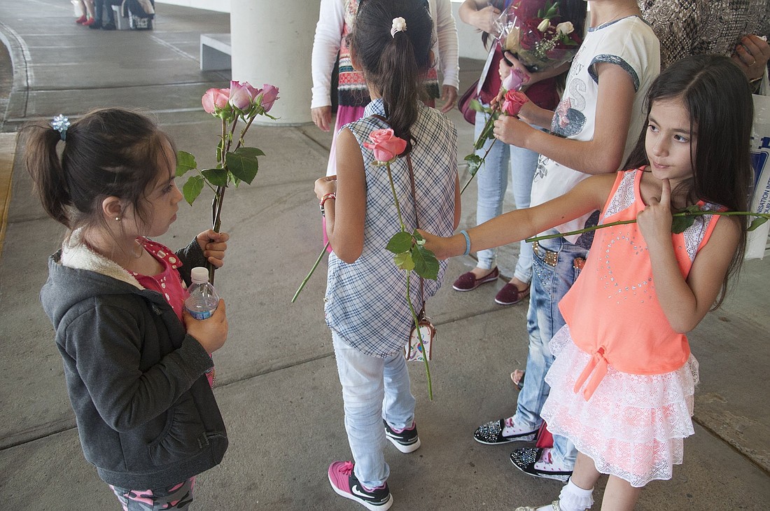 A file photo shows a young Kurdish refugee girl receiving a rose from a friend of the family in Nashville, Tenn. The girl's family had been in Turkey after fleeing Syria's civil war and was relocating to the U.S. Caseworkers from Catholic Charities of Tennessee also were on hand to greet the refugees and offer case management services to the family as they resettled in the U.S. (OSV News photo/Theresa Laurence, Tennessee Register)