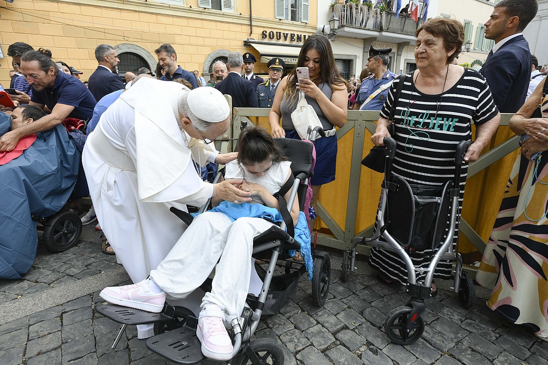 Pope Leo XIV greets a young woman in a wheelchair after leading the recitation of the Angelus prayer in front of the papal palace in Castel Gandolfo, Italy, Aug. 17, 2025. (CNS photo/Vatican Media)