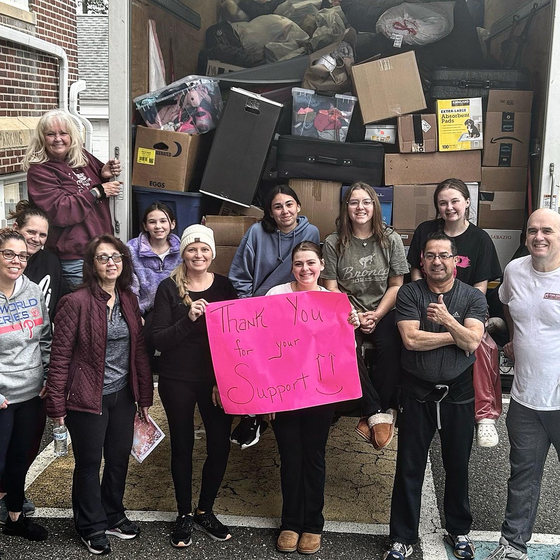 Members of the parish youth group stand by the truck that's loaded with items from their spring clothing drive. Courtesy photo