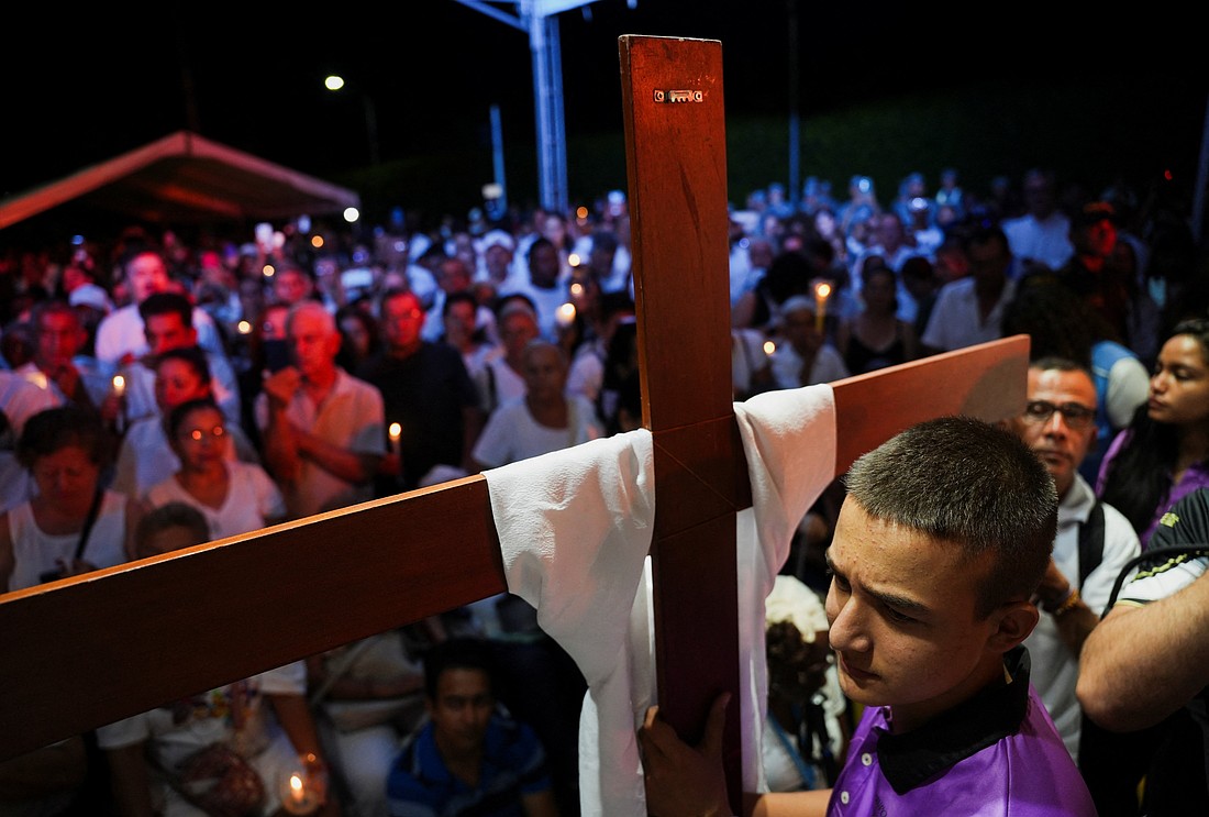 A member of the Catholic Church carries a cross during a candlelight vigil in Cali, Colombia, Aug. 24, 2025, in honor of victims of a cargo vehicle bomb attack near a Colombian Aerospace Force base, attributed to FARC dissident groups, that caused multiple casualties. At least 18 people have been killed and dozens wounded in two separate attacks in Colombia, deepening the country's most serious security crisis in decades. (OSV News photo/Jair F. Coll, Reuters).