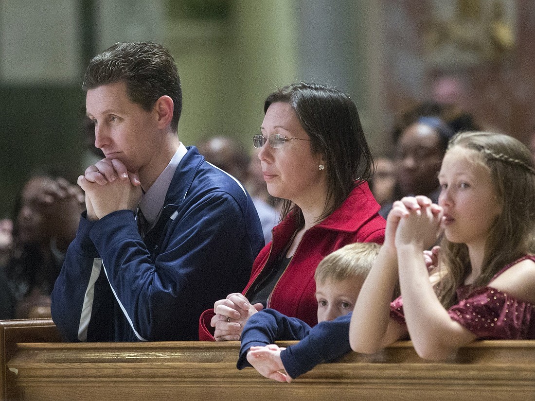 A file photo shows a family praying during Mass at the Cathedral of St. Matthew the Apostle in Washington. (OSV News photo/Jaclyn Lippelmann, Catholic Standard)