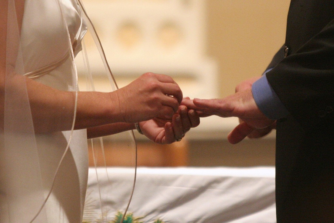 A file photo shows a bride places a ring on her groom's finger during their wedding. Does the church ever use the word 'divorce' or does it only talk about 'annulment?'. (CNS photo/Gregory A. Shemitz)