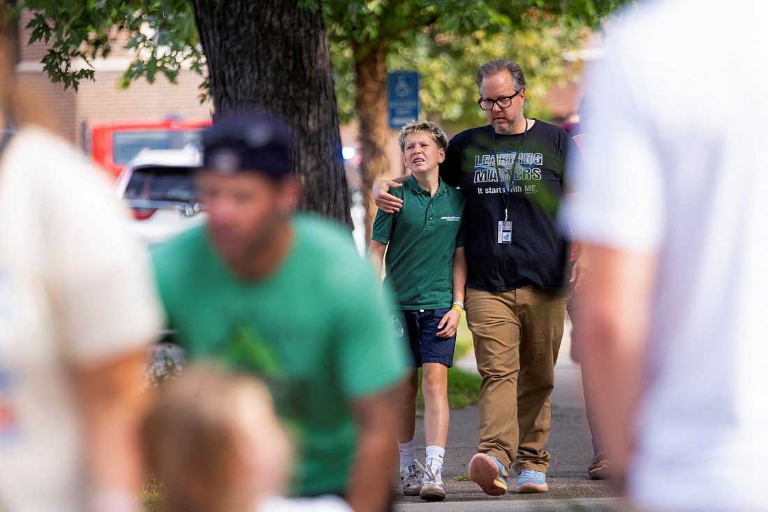 Families and loved ones walk outside the police barricades  following a shooting at Annunciation Catholic School in Minneapolis Aug. 27, 2025. A gunman opened fire with a rifle into the school church during Mass for the first week of school, killing two children and wounding 17 people, most of them children, in an act of violence the police chief called "absolutely incomprehensible." (OSV News photo/Ben Brewer, Reuters)