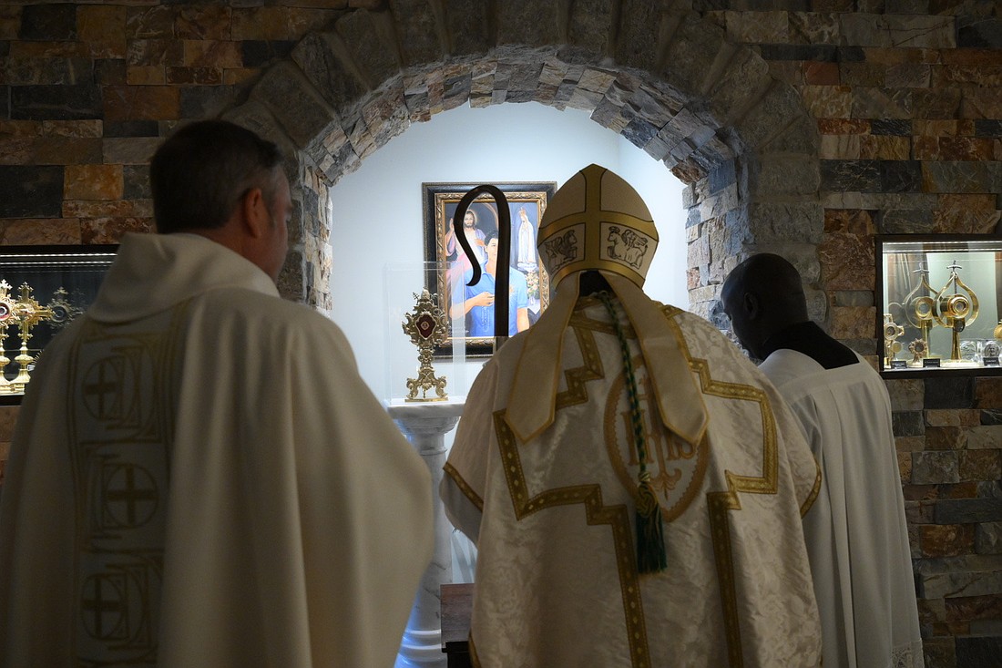 Before the start of Mass in St. Dominic Church, Bishop O'Connell pauses at the shrine that's dedicated to St. Carlos Acutis located in St. Dominic Church, Brick. Mike Ehrmann photos