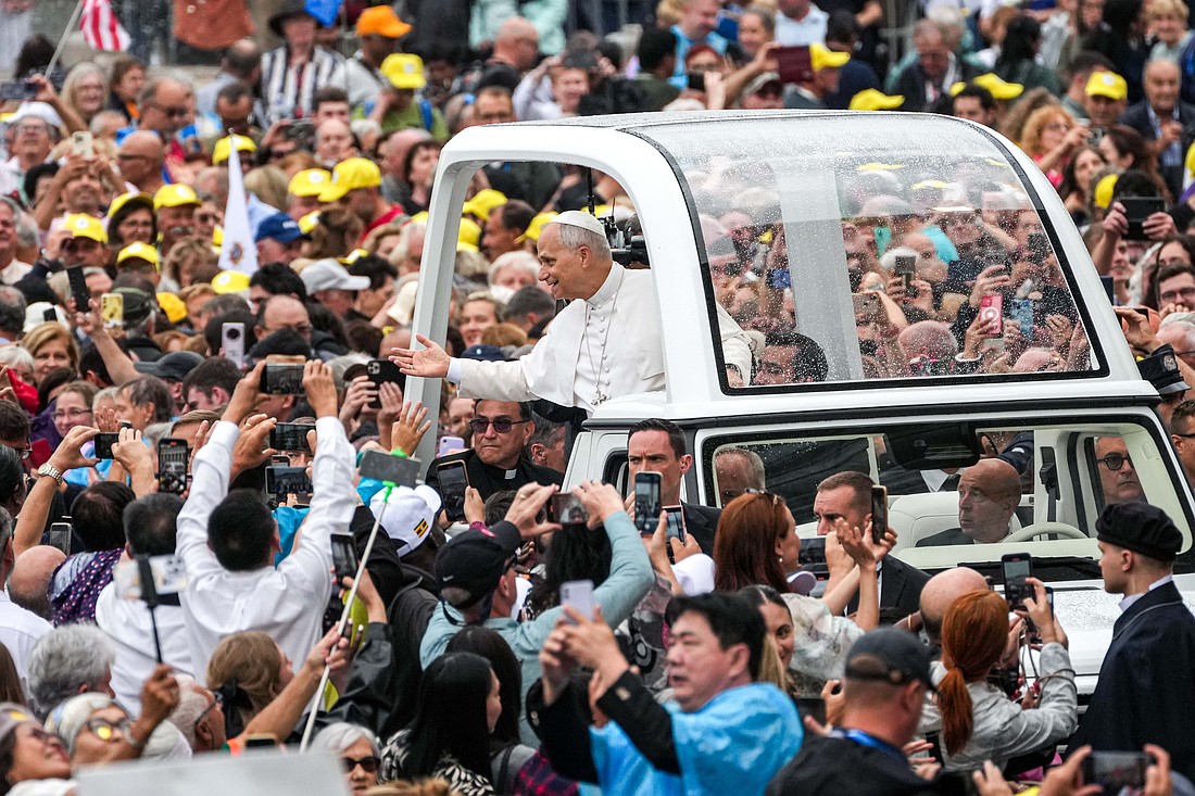 Pope Leo XIV greets visitors and pilgrims from the popemobile under the rain in St. Peter’s Square at the Vatican before his weekly general audience Sept. 10, 2025. (CNS photo/Lola Gomez)