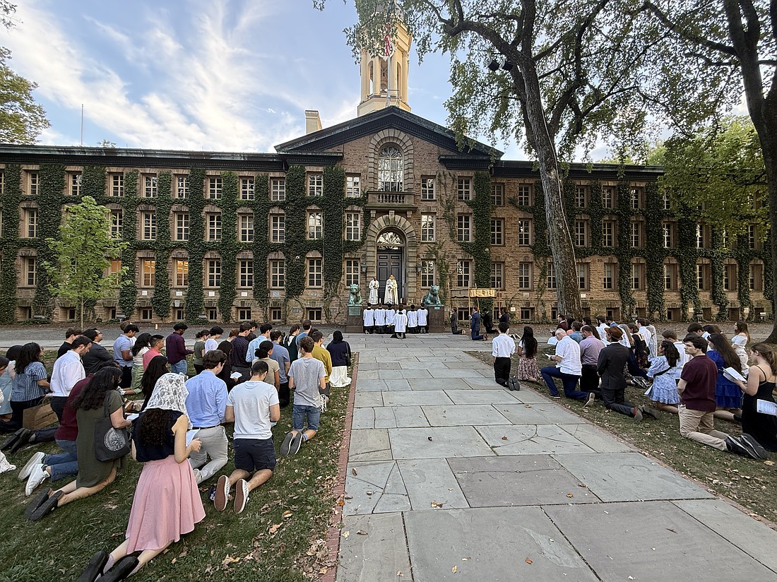 Adorers kneel before the Blessed Sacrament on Princeton University campus during a Sept. 14 Eucharistic Procession for the Feast of the Exaltation of the Holy Cross. Participants attended an afternoon Mass in the University Chapel celebrated by Father Zachary Swantek, Aquinas Institute chaplain, then joined the procession from the chapel throughout university grounds. EmmaLee Italia photo