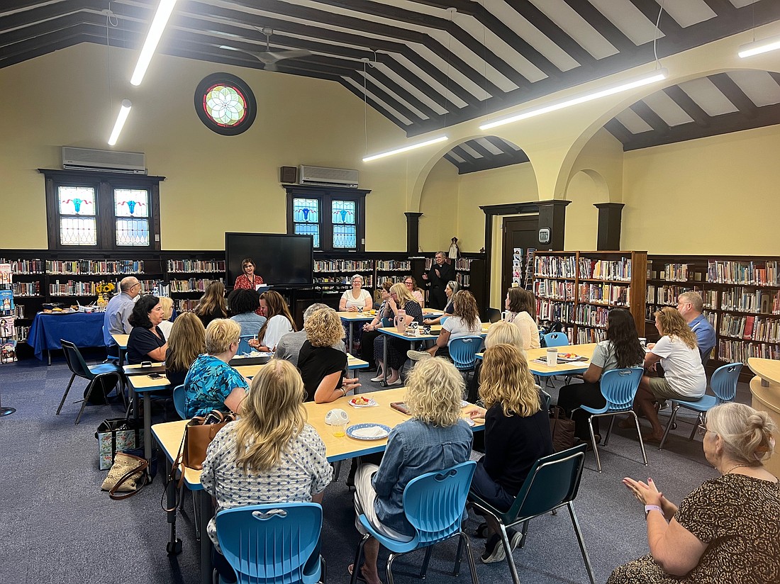 Principal Joanna Barlow addresses faculty and staff of Sacred Heart School, Mount Holly, gathered Aug. 27 in the newly renovated library for a grand re-opening, with blessing by Father John P. Czahur, pastor, standing right. The library now serves as a vital center for school classes, PTA and church meetings. Courtesy photo