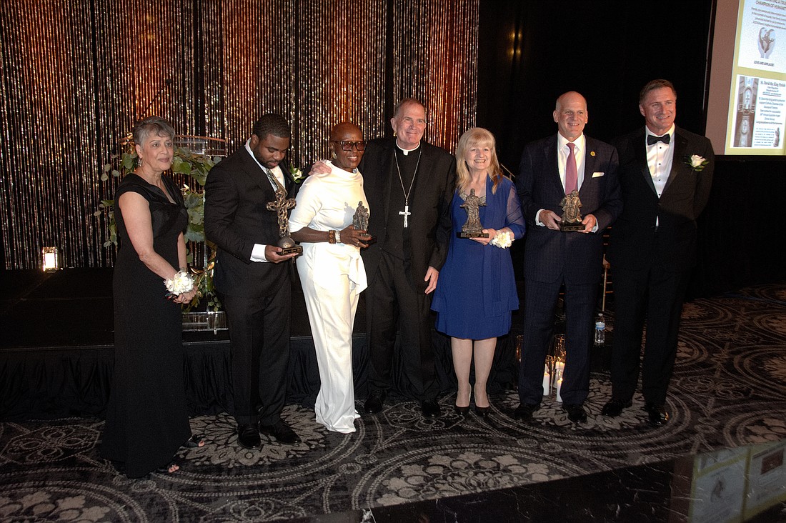 Bishop O'Connell, center is pictured with award recipients as well as Marlene Lao-Collins, executive director of Catholic Charities, left, and Michael Herbert chair of the agency's board of trustees. Joe Moore photo