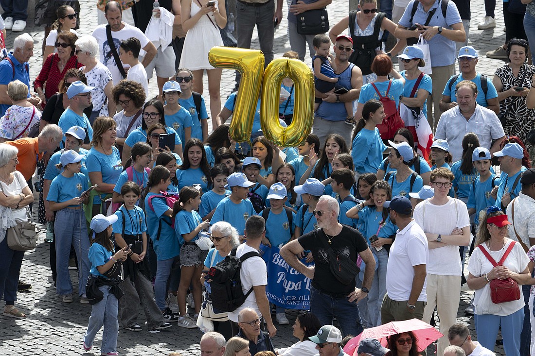 Un grupo de niños de una parroquia italiana sostiene dos globos dorados de mylar con los números "7" y "0" mientras se unen a otros visitantes en la Plaza de San Pedro del Vaticano para el rezo del Ángelus del Papa León XIV y para desearle un feliz 70.º cumpleaños el 14 de septiembre de 2025. (Foto CNS/Vatican Media)