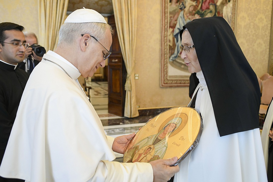 Pope Leo XIV receives a gift from a member of the Discalced Carmelite Sisters of the Holy Land during an audience at the Vatican Sept. 22, 2025, with members of her order and other women's congregations holding their general chapter meetings in Rome. (CNS photo/Vatican Media)