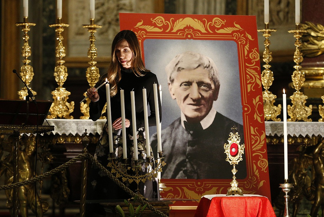 Melissa Villalobos of Chicago lights a candle during a vigil in advance of the canonization of St. John Henry Newman, at the Basilica of St. Mary Major in Rome Oct. 12, 2019. Villalobos' healing through the intercession of St. John Henry Newman was accepted as the miracle needed for the British cardinal's canonization.  (CNS photo/Paul Haring) See SAINTS-NEWMAN-VIGIL to come.