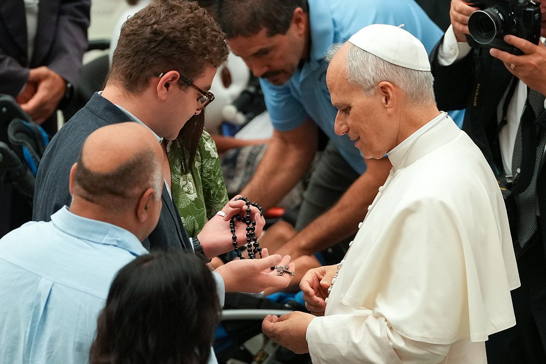 El Papa León XIV saluda a un joven que sostiene un rosario durante su audiencia general en el Aula Pablo VI del Vaticano, el 13 de agosto de 2025. (Foto CNS/Vatican Media)