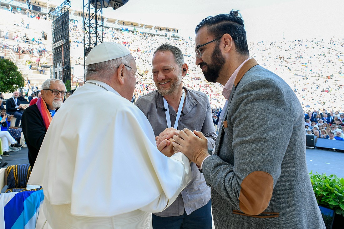 Pope Francis clasps the hands of Maoz Inon, center, an Israeli whose parents were killed Oct. 7 by Hamas militants, and Aziz Sarah, right, a Palestinian whose brother was killed by Israeli soldiers, during a meeting at the Arena in Verona, Italy, May 18, 2024. (CNS photo/Vatican Media)