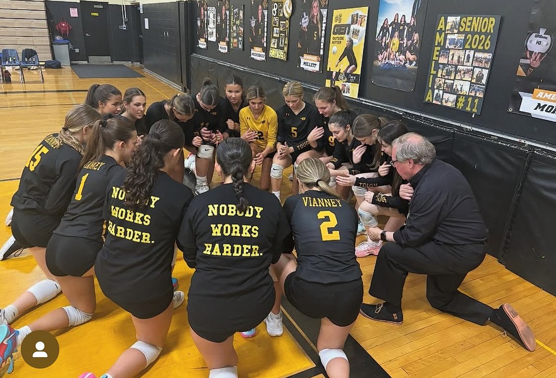 The St. John Vianney girls volleyball team says a pre-game prayer with Father Garry Koch, pastor of St. Benedict Parish, Holmdel. Photo by Pat Smith