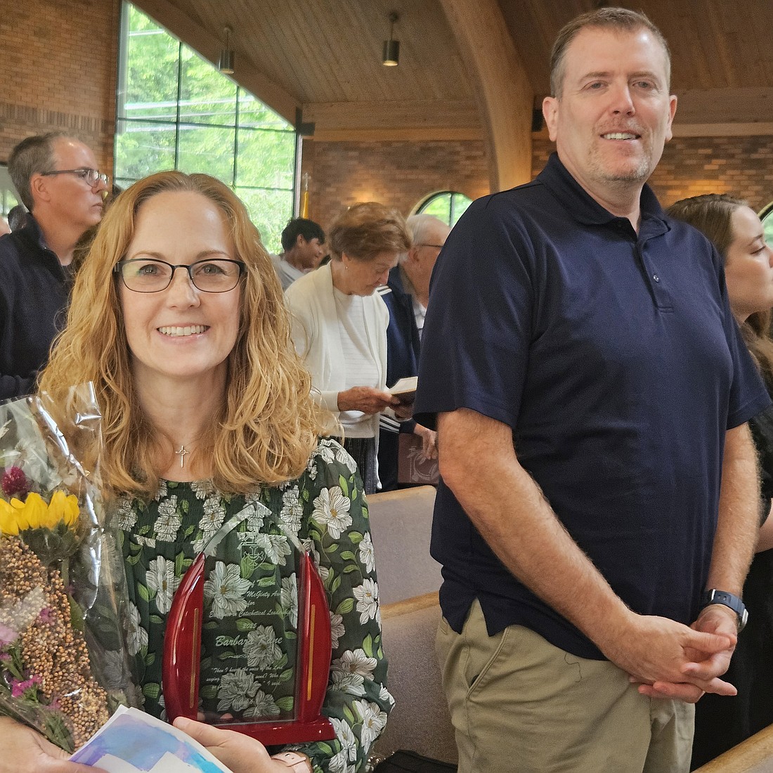 Holding a bouquet of flowers in one hand and her award in the other, Barbara Kane and her husband Ryan smile for a photo. Mary Stadnyk photo