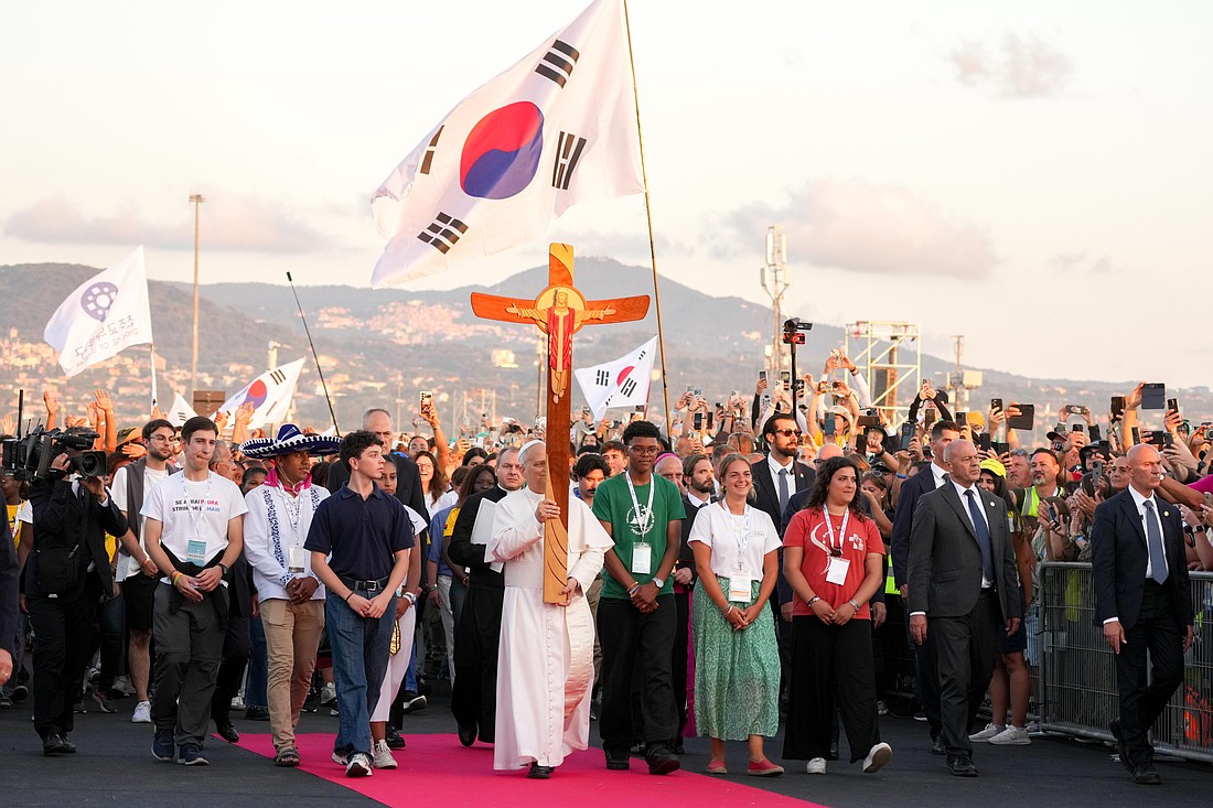 Pope Leo XIV carries the Jubilee Cross as he walks to the altar before the start of a prayer vigil with young people gathered in Tor Vergata in Rome Aug. 2, 2025, during the Jubilee of Youth. (CNS photo/Lola Gomez)