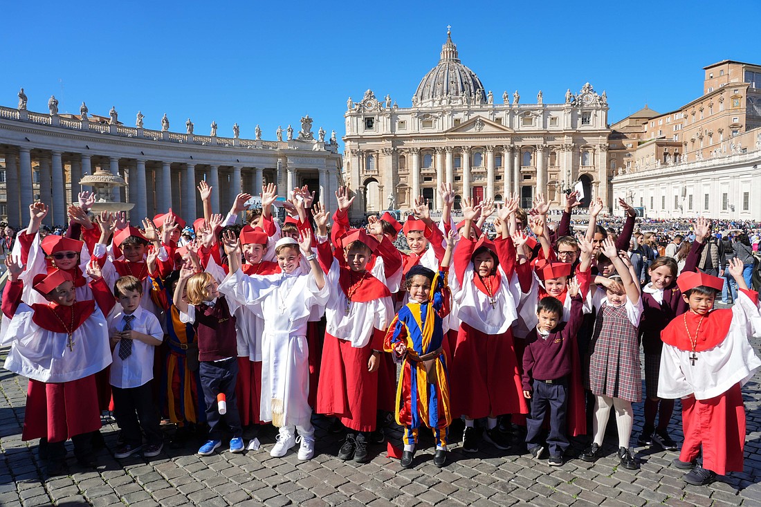 Students from Our Lady of Mount Carmel Academy in Chicago dressed as cardinals, a Swiss Guard and a pope pose in St. Peter’s Square at the Vatican Oct. 8, 2025. The students had captured worldwide attention when they held a mock conclave at their school May 6, electing their own “pope,” fourth grader Augie Wilk, who took the name “Pope Augustine,” just days before the election of Pope Leo, a fellow Chicagoan and Augustinian. (CNS photo/Lola Gomez)