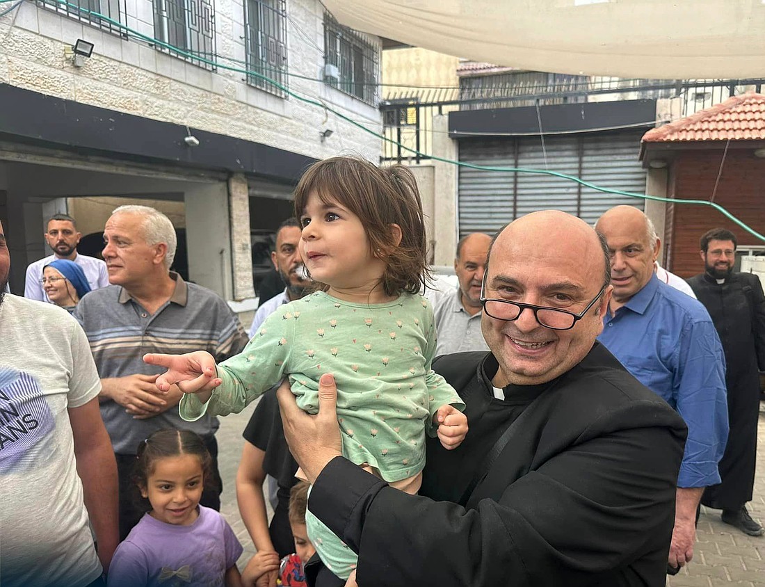 Father Gabriel Romanelli, pastor of Gaza City's Holy Family Parish, is seen with a child from the Catholic parish in Gaza City during the May 16-19, 2024, visit of the Latin patriarch of Jerusalem, Cardinal Pierbattista Pizzaballa, to the Gaza Strip. (OSV News photo/courtesy Latin Patriarchate of Jerusalem)