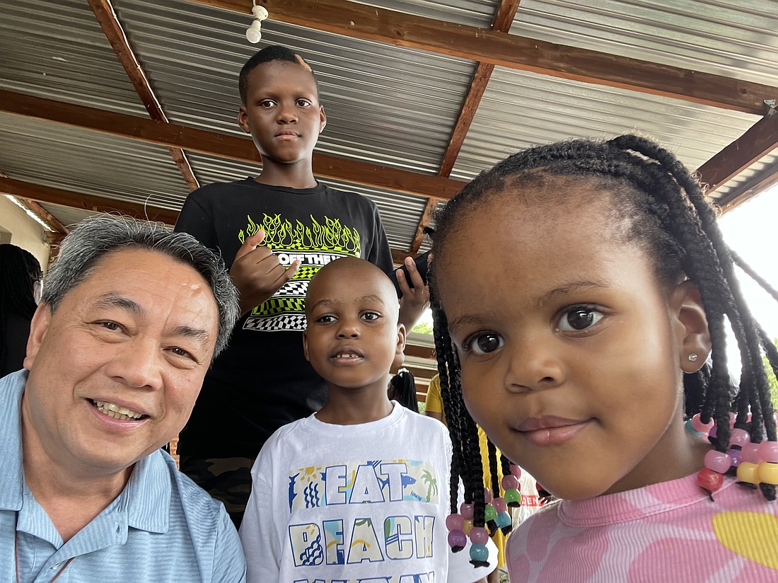 Father Alindogan, left, takes a selfie with children he met on his mission trip to South Africa. Courtesy photo