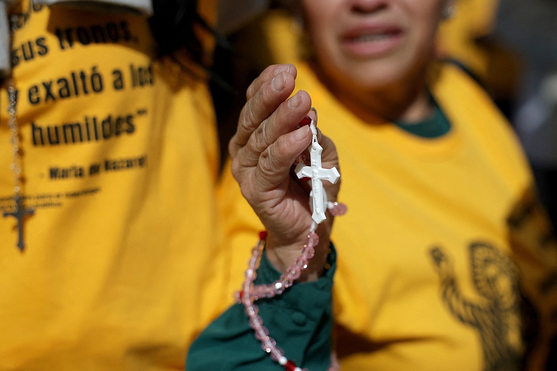 A woman holds a rosary as members of a Catholic group take part in a Eucharistic procession near the U.S. Immigration and Customs Enforcement (ICE) Broadview facility in Chicago Oct. 11, 2025. The group had hoped to share holy Communion with detainees at the facility. (OSV News photo/Jeenah Moon, Reuters)