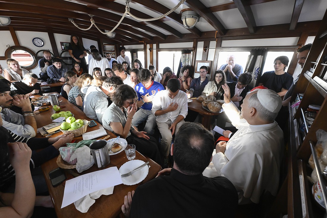 Pope Leo XIV gives his blessing to young adults aboard the "Bel Espoir" sailboat in the Ostia marina outside Rome Oct. 17, 2025. In rotating crews of 25, young adults have been sailing around the Mediterranean to speak about peace with their peers. (CNS photo/Vatican Media)