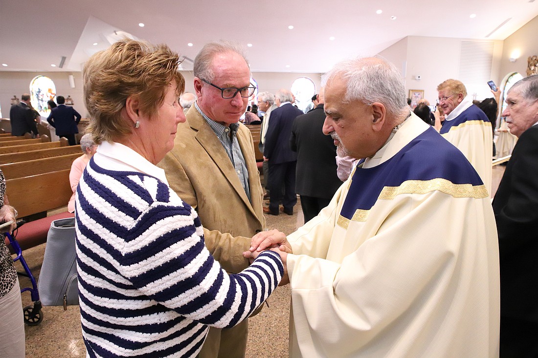 Msgr. Sam Sirianni, rector of St. Robert Bellarmine Co-Cathedral, bestows a blessing on a couple marking a milestone anniversary following the Oct. 19 Mass. John Batkowski photo