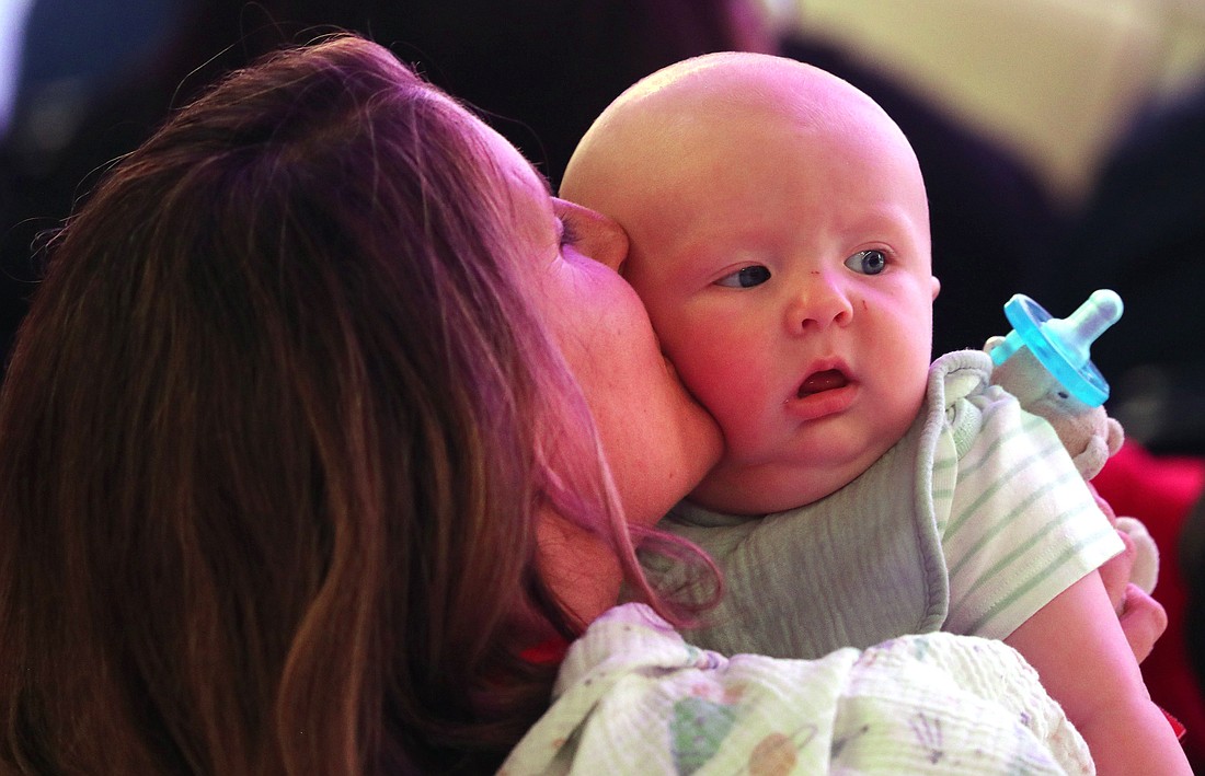 A mother kisses her baby July 19, 2024, during the revival night of the National Eucharistic Congress at Lucas Oil Stadium in Indianapolis. (OSV News photo/Bob Roller)