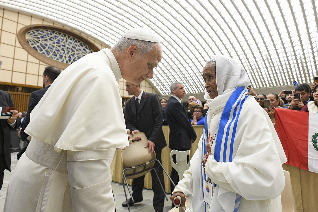 Pope Leo XIV greets a woman during a gathering of popular movements as part of their Jubilee in the Paul VI Audience Hall at the Vatican Oct. 23, 2025. (CNS photo/Vatican Media)
