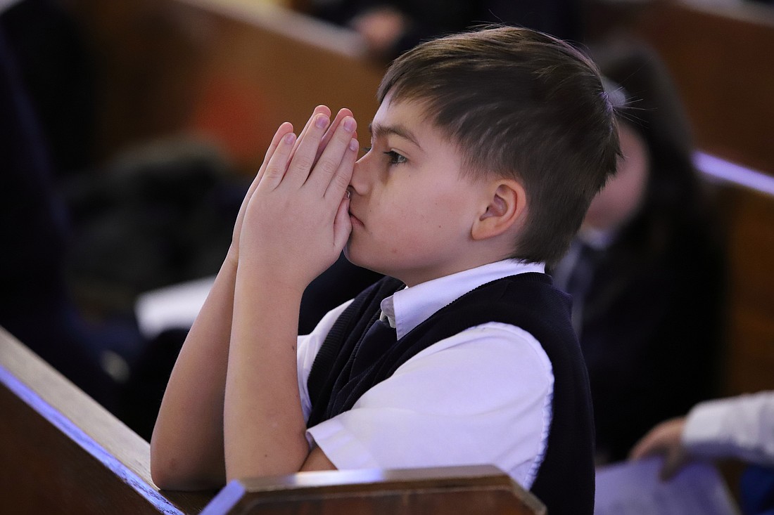 A student from St. Jerome School, West Long Branch, prays during a Catholic Schools Week Mass celebrated earlier this year. John Batkowski photo