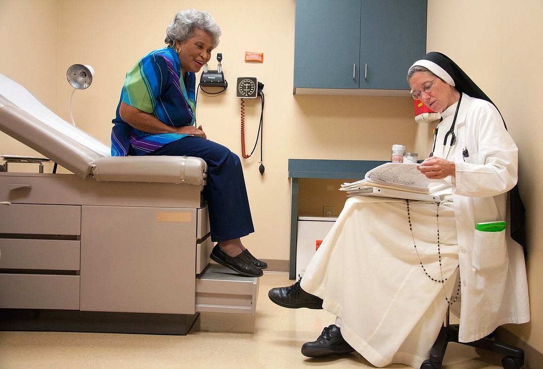 Dominican Sister Mary Diana Dreger, a medical doctor, is pictured in a file photo talking with a patient at St. Thomas Family Health Center South in Nashville, Tenn. (OSV News photo/Theresa Laurence, Tennessee Register)