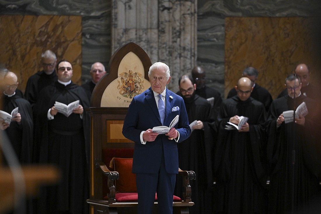 Britain's King Charles III stands in front of a chair made to mark his being honored as a "royal confrater" of the Benedictine monks at the abbey at Rome's Basilica of St. Paul Outside the Walls during an ecumenical prayer service Oct. 23, 2025. (CNS photo/Vatican Media)