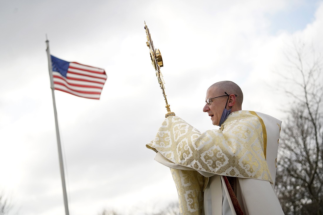Father Liam McDonald, pastor of St. Therese of Lisieux Church in Montauk, N.Y., holds a monstrance containing the Blessed Sacrament as he leads a Eucharistic procession in Montauk in observance of Religious Freedom Day Jan. 16, 2022. The U.S. observes International Religious Freedom Day Oct. 27 to commemorate the signing of the International Religious Freedom Act in 1998. (OSV News photo/CNS file, Gregory A. Shemitz)