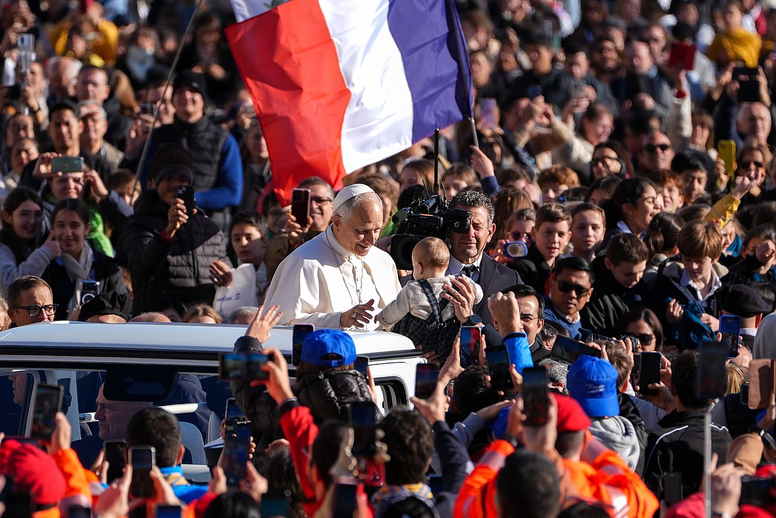 Pope Leo XIV greets a child from the popemobile as he rides around St. Peter's Square at the Vatican before his weekly general audience Nov. 19, 2025. (CNS photo/Lola Gomez)