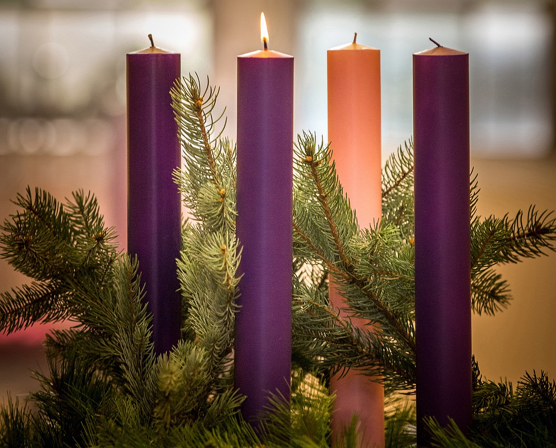 A lit candle is seen on an Advent wreath. Advent, a season of joyful expectation before Christmas, begins Nov. 27 this year. The Advent wreath, with a candle marking each week of the season, is a traditional symbol of the liturgical period. (CNS photo/Lisa Johnston, St Louis Review)