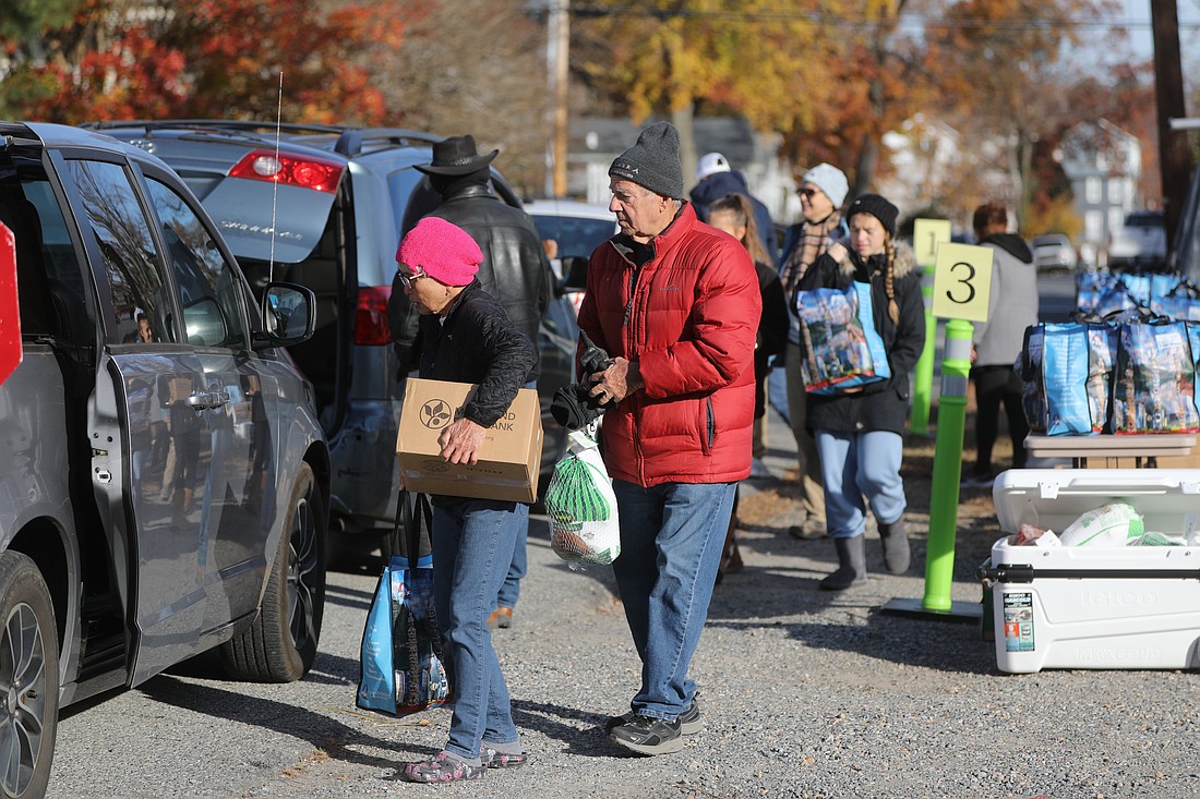 Volunteers with the Ladies of Charity of Calvert County, Md., load turkeys and other provisions into the car of a person in need at a food pantry Nov. 20, 2021, held on the grounds of of St. Anthony's Catholic Church in North Beach. (OSV News photo/Bob Roller)