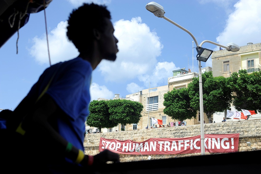 A man walks past a banner reading "Stop Human Trafficking!" in 2018 in Valletta, Malta. Msgr. Marco Formica, counselor at the Holy See's permanent observer mission to the U.N., spoke at a Nov. 25, 2025, high-level meeting on appraising the U.N.'s Global Plan of Action to Combat Trafficking in Persons. (OSV News photo/Guglielmo Mangiapane, Reuters)